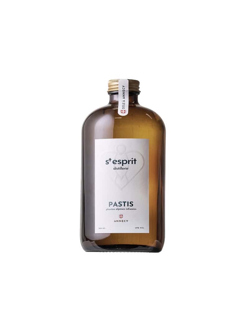 Bouteille en verre ambré de pastis artisanal de la Distillerie du Saint-Esprit à Annecy. Étiquette blanche avec logo "St-Esprit distillerie", mention "PASTIS" et "plantes alpines infusées ».