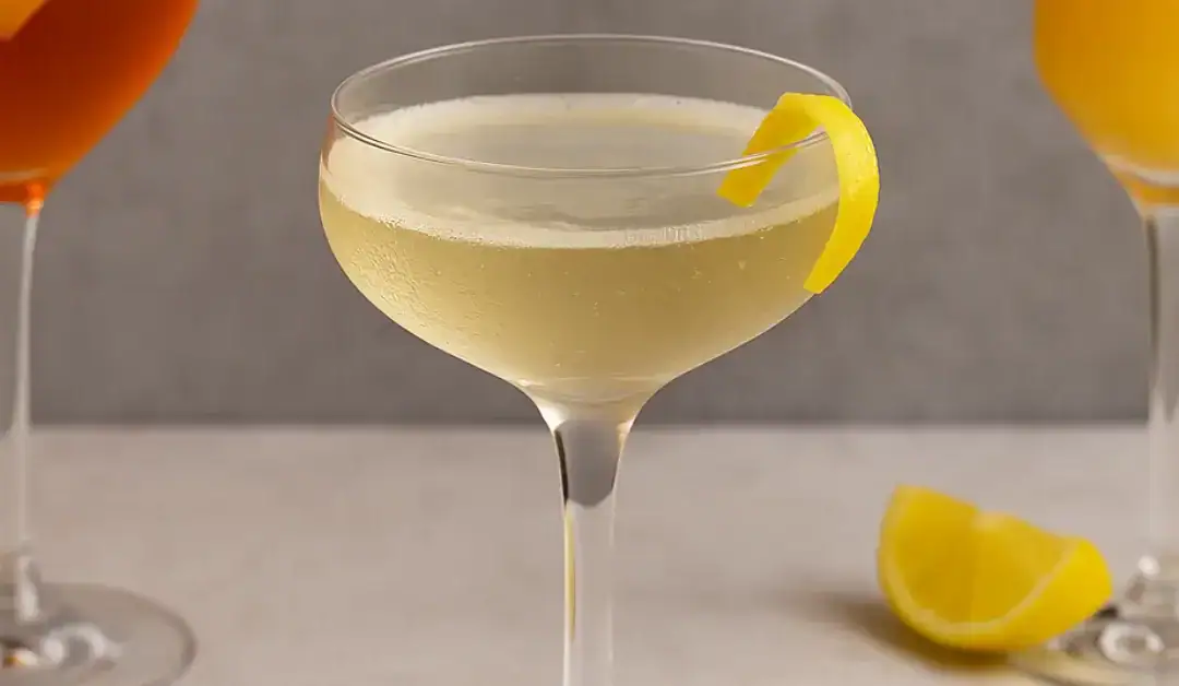 Cocktail à base de Prosecco servi dans une coupe élégante, garni d’un zeste de citron, avec en arrière-plan un Spritz et un Mimosa flous.