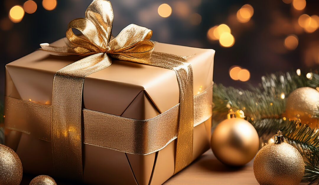 Coffret doré entouré de décorations de Noël, représentant une idée de box cadeau gourmande et festive à offrir pendant les fêtes de fin d’année