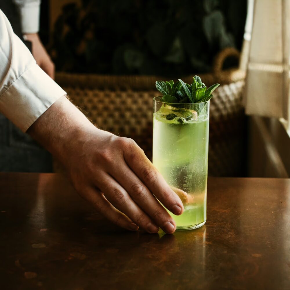 Main servant un cocktail maison à la menthe lors d’un atelier cocktail en Savoie